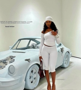 Detail of white two-piece set featuring asymmetrical neck top and slim-fit shorts