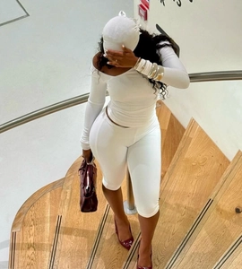 Detail of white two-piece slim fit set with off-shoulder top and matching shorts