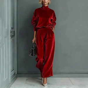 Detail of burgundy velvet track suit featuring a high neck zipper top and wide leg pants