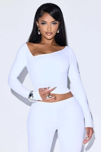 Detail shot of white asymmetric collar long sleeve top and slim fit pants set for women
