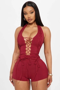 Close-up of wine red halter romper featuring criss-cross lace-up details and ribbed knit