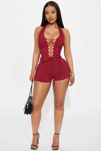 Detailed view of burgundy lace-up halter top and ribbed slim shorts with premium texture