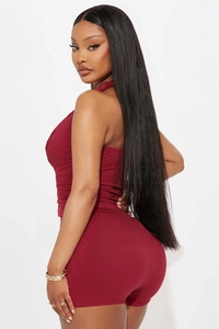 Detail view of the burgundy ribbed knit halter top and high-waisted shorts on a model