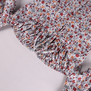 Detail view of floral French slit dress showing drawstring bow and puffed sleeves fabric