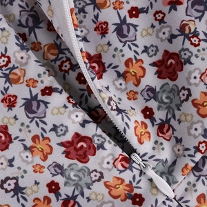 Close-up of floral print fabric with a white invisible zipper on the midi dress