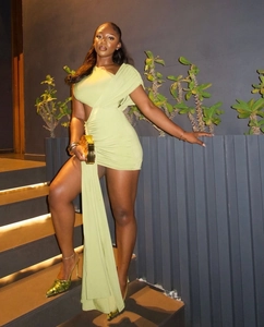 Détail de la mini-robe asymétrique vert clair avec découpe latérale et long ruban fluide