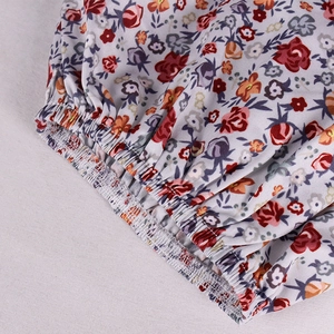 Detail of elastic smocked waist on a French floral print summer dress with fine stitching