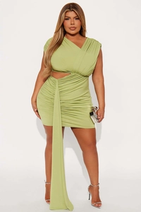 Détail de la robe mini vert avocat avec découpe latérale à la taille et tissu froncé