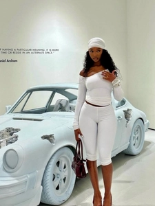 Elegant white two-piece knit set featuring asymmetric off-shoulder top and cropped pants