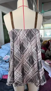 Detail of pink plaid tank top featuring brown velvet straps and ruffled hem design
