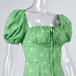 Detail of square neck floral dress featuring puff sleeves and green drawstring bodice