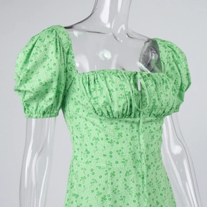Detail of green floral dress with square neckline and adjustable drawstring tie