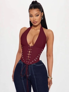 Sexy burgundy halter neck lace-up corset top paired with dark denim jeans