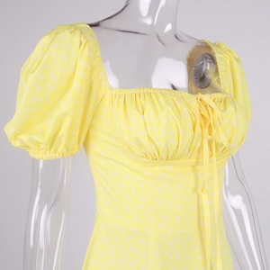 Close-up of square neckline with drawstring and puff sleeves on yellow floral dress