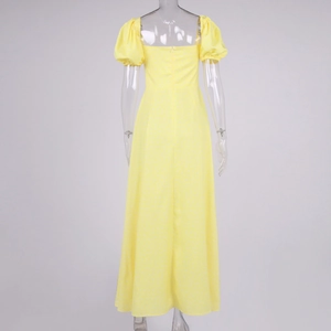 Detail view of yellow floral dress featuring back zipper and square neck with puff sleeves