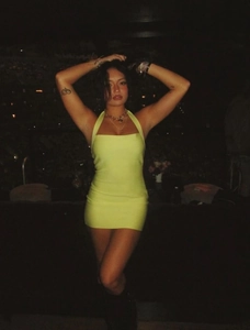 Dettaglio mini abito aderente giallo neon con scollo all'americana e trama a coste