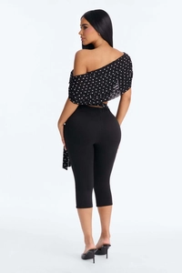 Rear view of polka dot off-shoulder top and high-waisted black cropped leggings set