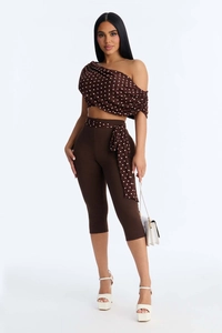 Detail view of brown polka dot off-shoulder top and cropped leggings with waist belt
