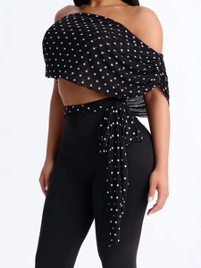 Chic two-piece set featuring a black polka dot off-shoulder top and high waist pants