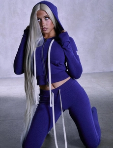 Détail d'un ensemble de sport violet foncé ajusté avec cordons blancs et fermeture éclair
