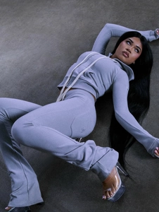 Gros plan sur le tissu bleu-gris de l'ensemble de fitness avec logo et maille côtelée
