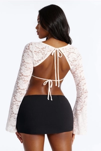Détail du haut court en dentelle blanche avec dos nu et fermeture à lacets croisés