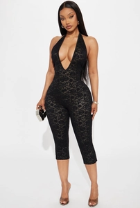 Detailed view of black floral lace fabric on a halter neck jumpsuit with deep V-neck