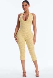 Detailed close-up of pale yellow floral lace fabric on a sexy halter neck jumpsuit