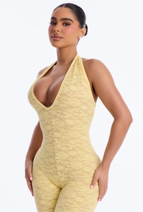 Close-up of intricate floral lace texture and deep V-neckline on yellow bodysuit