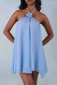 Detail of light blue polka dot dress featuring a 3D floral accent on the halter neckline