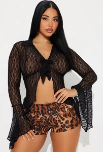 Detail of the sheer black lace top with flared sleeves and a delicate front tie closure
