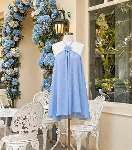 Close-up of light blue halter dress with detailed 3D fabric flower and floral mesh