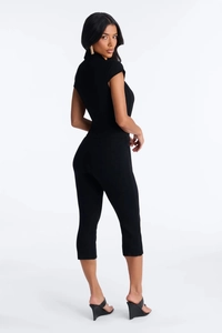 Detail view of the sleek black short sleeve V-neck jumpsuit in premium elastic knit fabric