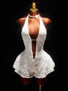 Detailed view of floral lace texture on white deep V-neck halter romper with pearl necklace