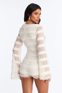 Détail d'un combishort en dentelle blanche avec manches cloche et motifs cœurs