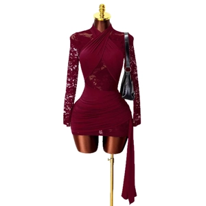 Robe moulante rouge foncé avec manches en dentelle et détails plissés sur fond blanc
