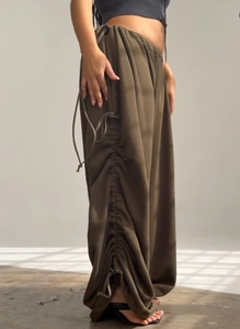 Detail of loose fit trousers with side drawstring and textured cotton fabric