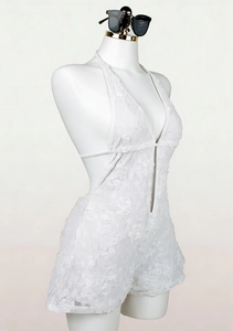 Detail of white lace bodysuit with floral embroidery, deep V-neck and open back design