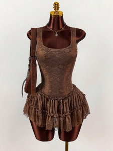 Detailed close-up of brown lace cake dress with three-layer pleated hem and U-neckline