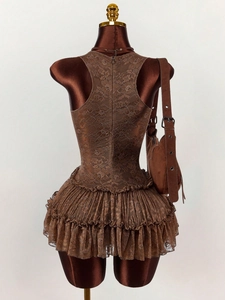 Detail of dark brown floral lace textures and tiered ruffle layers on a summer dress