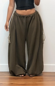 Detail of adjustable drawstring waistband and olive green heavyweight fabric trousers