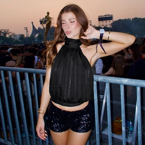 Detail of black halter neck top with pleated texture and sequined party shorts