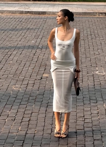 Détail d'une robe blanche deux pièces avec gilet ajusté et inscription de logo noir