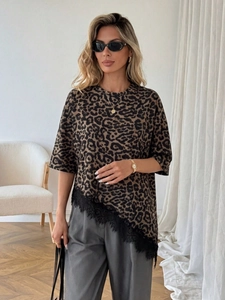 Detail of leopard print t-shirt featuring asymmetric black lace trim at the hemline