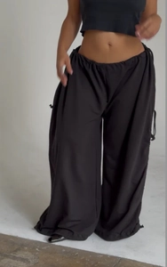 Macro detail of black wide-leg parachute pants with adjustable drawstring waist and hem