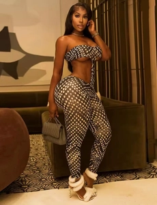 Detail of two-piece set featuring black and white checkerboard crop top and tight trousers