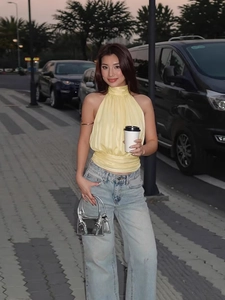 Fashionable pale yellow halter neck top with high waist straight blue jeans outfit