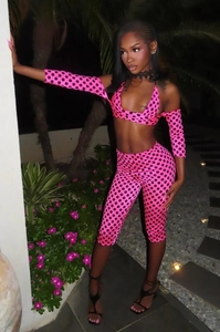 Detail von rosa gepunktetem Neckholder-Top und Leggings-Set mit Ärmeln im Garten bei Nacht