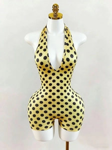 Dettaglio della tutina gialla a pois con scollo all'americana e profondo scollo a V