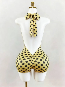 Dettaglio di una tutina gialla a pois neri con scollo all'americana e arricciatura posteriore